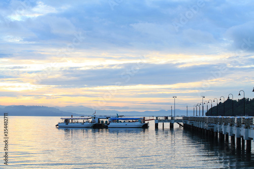 Boat resting near a jetty with sunrise background