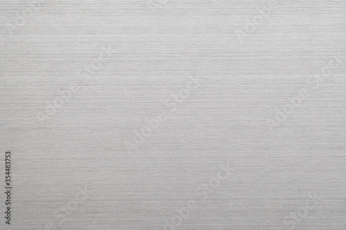 Abstract metal texture of brushed stainless steel plate with the reflection of light.