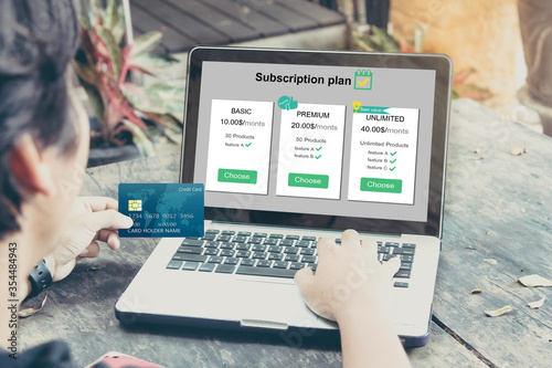 Subscription business model concepts.Man hands holding credit card and using laptop or pc
