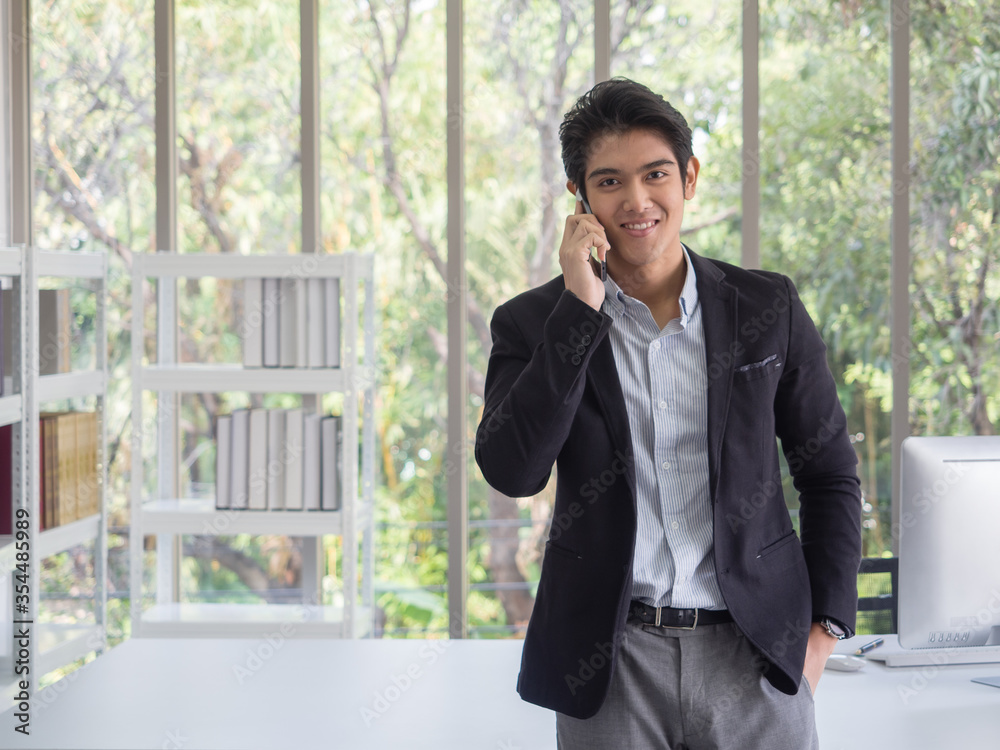Asian businessman are happy hold hand telephone send emails to clients to contact work in the office.Play games,social media,type text.The green tree background in the garden and copy space Asian businessman are happy hold hand telephone send emails to clients to contact work in the office.Play games,social media,type text.The green tree background in the garden and copy space