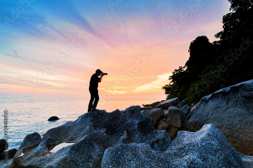 Silhouette view of male model photographer by sunrise or sunset background 