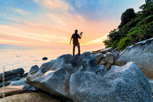 Silhouette view of male model photographer by sunrise or sunset background 