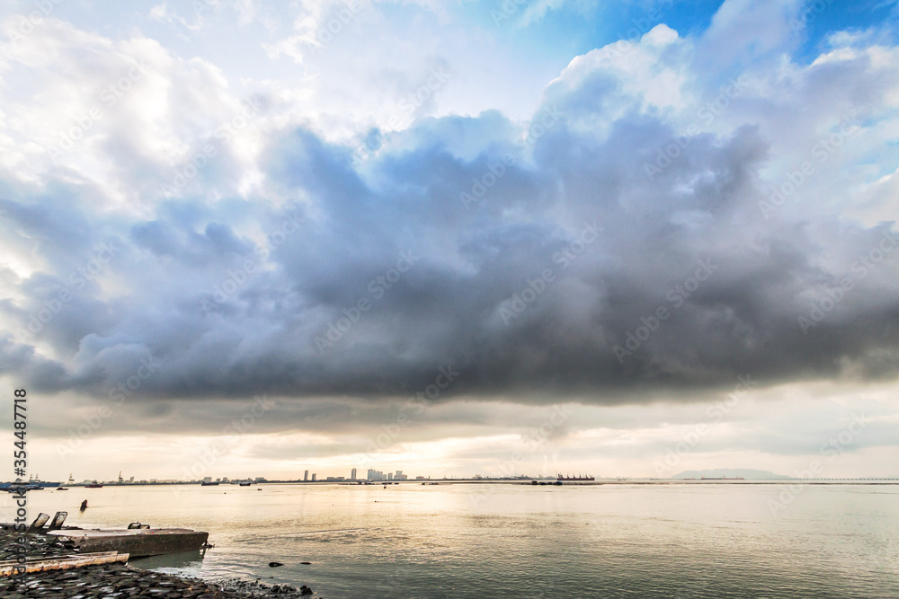 Obraz premium Cloudy storm view by the shore during sunrise