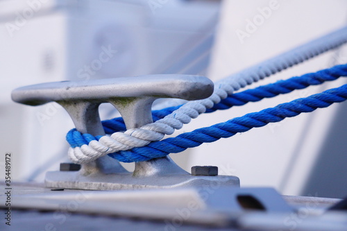 Bollard in the marina with blue and white rope. © Sailographic Paula