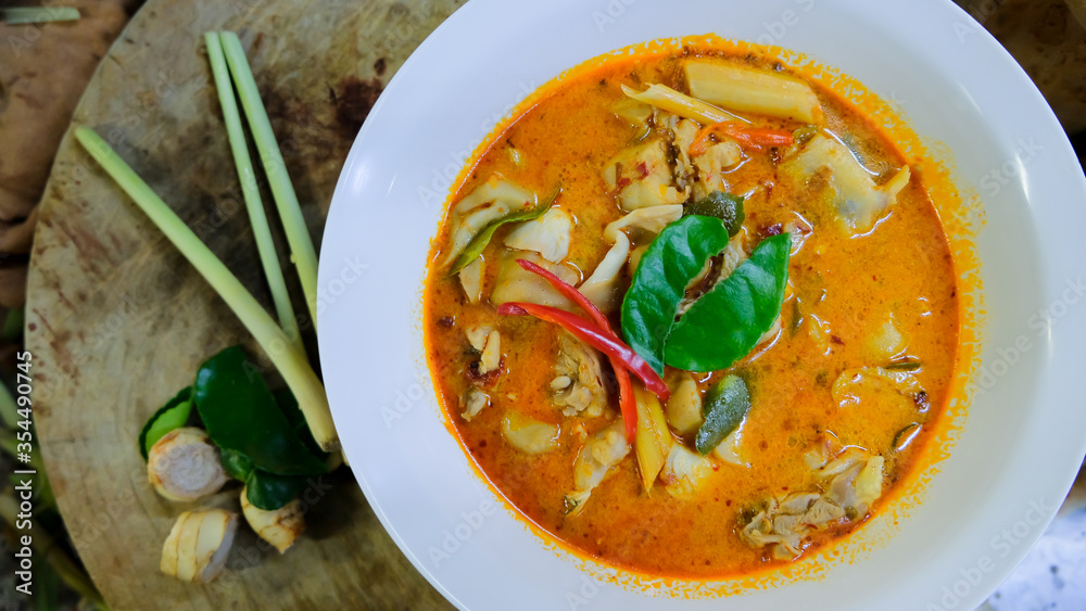 Top view of traditional thai popular famous yummy delicious food hot and spicy Tom yum soup on wooden board with ingredients in the kitchen at thai restaurant.