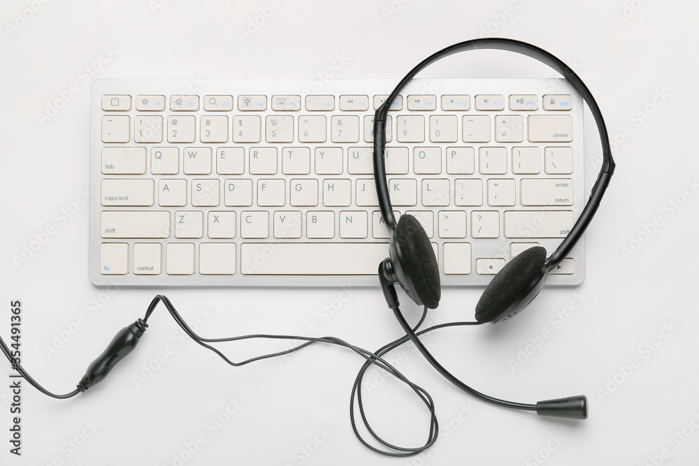 PC keyboard with headset on white background PC keyboard with headset on white background