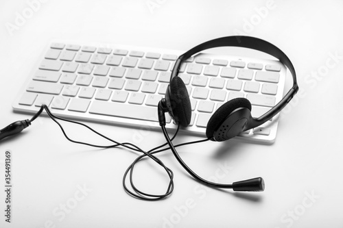 PC keyboard with headset on white background