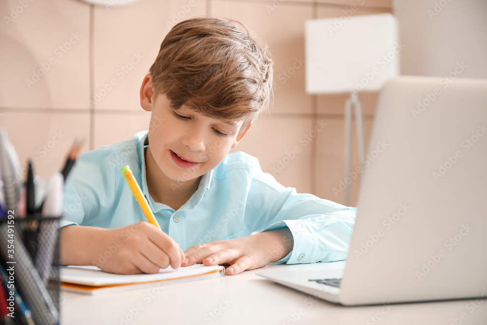 Cute little boy studying at home. Concept of online education Cute little boy studying at home. Concept of online education