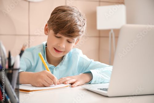 Cute little boy studying at...
