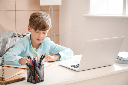 Cute little boy studying at...