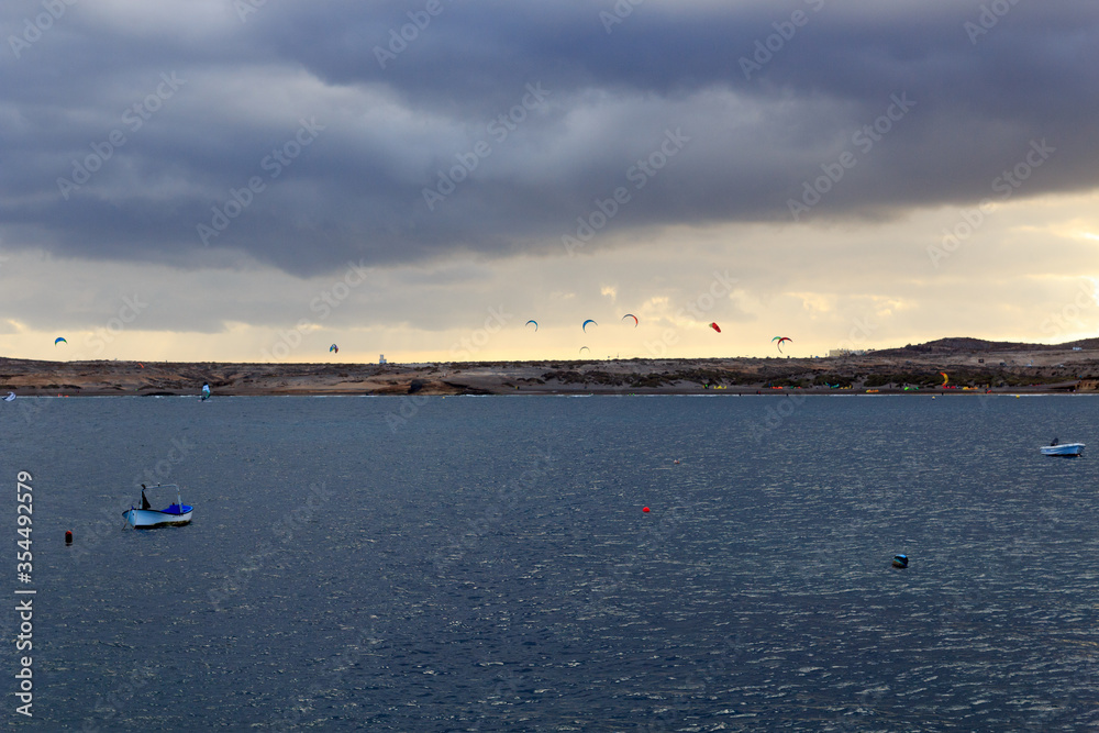 Bay of El Medano panorama with kitesurfers, Atlantic Ocean and dark clouds on Canary Island Tenerife, Spain