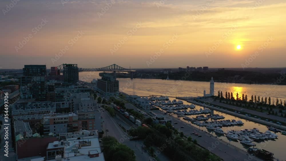 Drone showing a colorful sunrise on the St-Lawrence river marina on a summer day in Montreal, Quebec, Canada. Drone showing a colorful sunrise on the St-Lawrence river marina on a summer day in Montreal, Quebec, Canada.