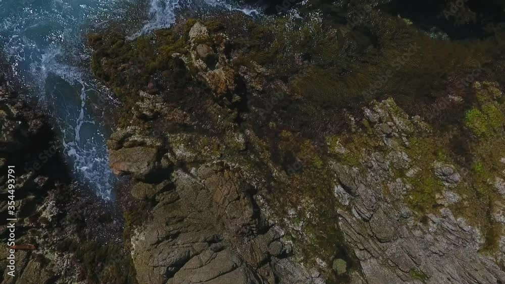 Aerial panning shot of rock formations in sea on sunny day, drone flying over beach - Lloret de Mar, Spain Aerial panning shot of rock formations in sea on sunny day, drone flying over beach - Lloret de Mar, Spain