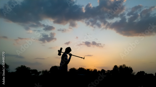 Silhouette of a farmer in the sunset low angle image