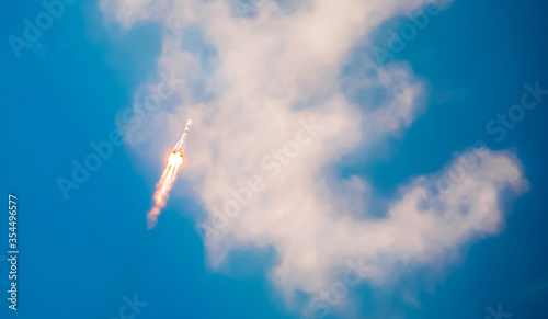 Take-off of a real launch vehicle from a spaceport. A rocket takes off into the sky against a background of clouds. Startup concept, power of science and technology. photo