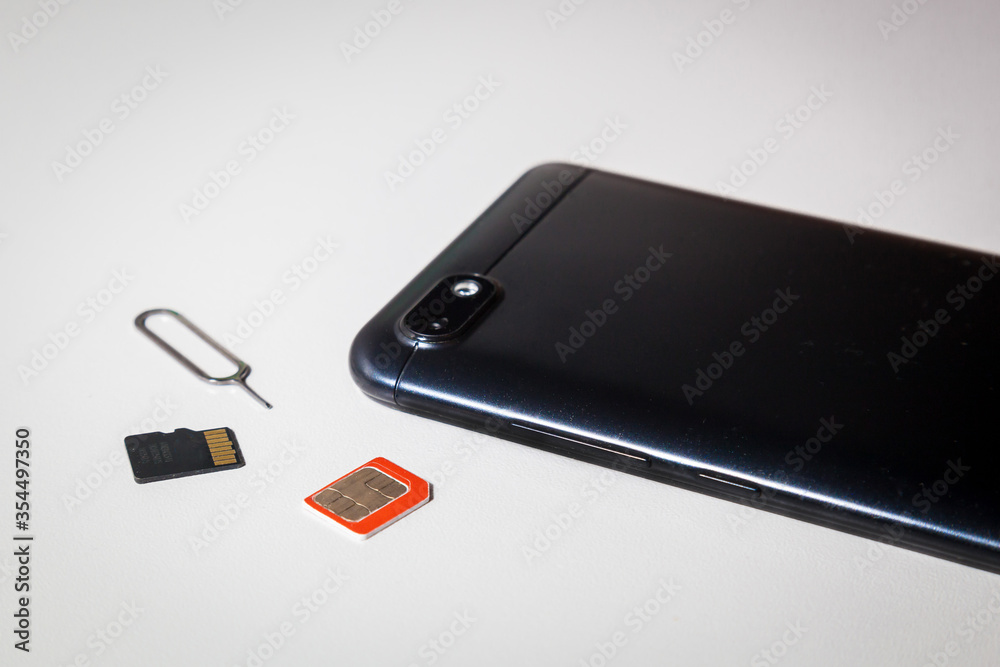 Smartphone, memory card, SIM card and key are on the table. Smartphone, memory card, SIM card and key are on the table.