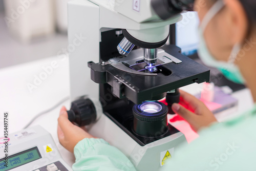 Doctor and microbiologist with vacuum tubes for samples with COVID 19 infection atypical pneumonia virus in laboratory photo