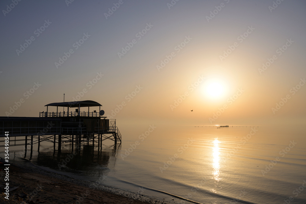 Silhouette fisherman wooden hut on seaview milky water over sunrise sky background, Bahrain. Silhouette fisherman wooden hut on seaview milky water over sunrise sky background, Bahrain.