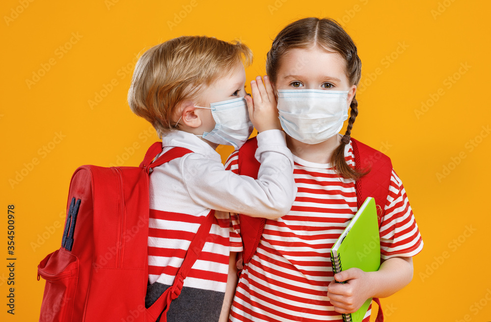 Children in masks gossiping during break in studies. - obrazy, fototapety, plakaty 