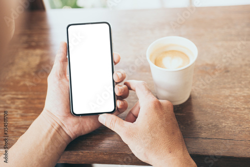 cell phone mockup image blank white screen.man hand holding texting using mobile on desk at coffee shop.background empty space for advertise.work people contact marketing business,technology