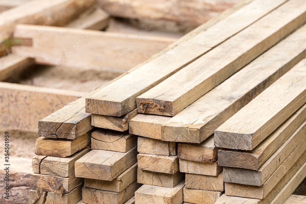 lumber stack of natural rough wooden boards on building site. material for construction. lumber stack of natural rough wooden boards on building site. material for construction.