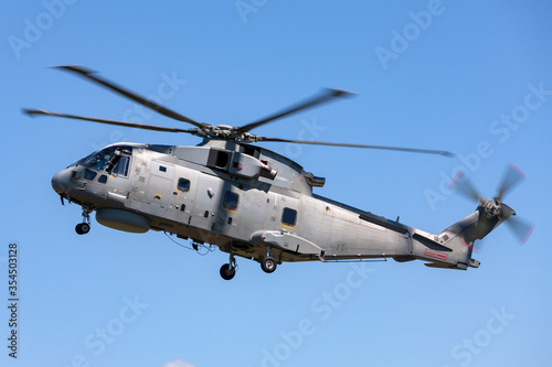 Large military helicopter flying in a clear blue sky. 