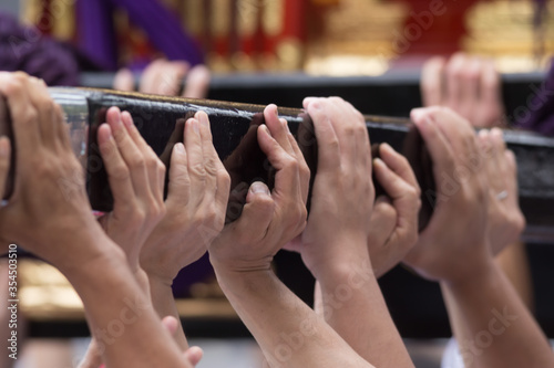 Chiba, Japan, 08/22/2019 , Hands of the participants of the 893rd Myoken Big Festival lifting the wooden structure that support the Mikoshi, a sacred religious palanquin (portable shinto Shrine)