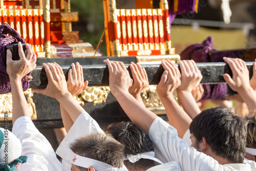 Chiba, Japan, 08/22/2019 , Hands of the participants of the 893rd Myoken Big Festival lifting the wooden structure that support the Mikoshi, a sacred religious palanquin (portable shinto Shrine) photo