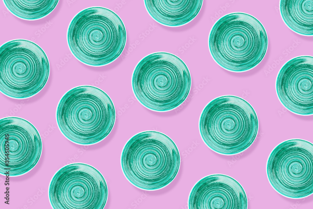 Light blue round ceramic plate with spiral pattern, light pink background Light blue round ceramic plate with spiral pattern, light pink background