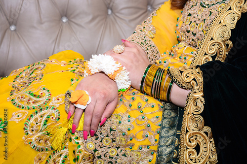 Indian Wedding Ceremony. Yellow Color Embroidery Bridal Lehenga. Close up of Dulhan / Woman's Hand with Ring and Traditional Bangles