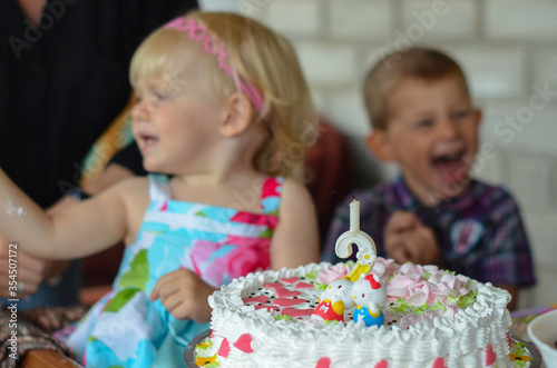 Brother and sister celebrate their birthday with a cake. Happy childhood. Festive mood