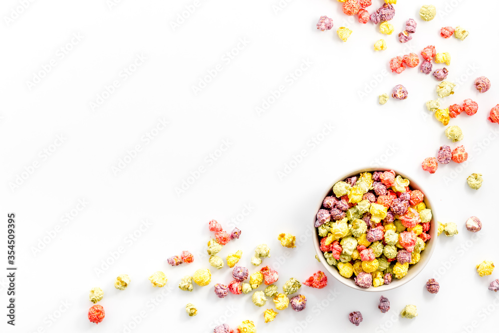 Obraz premium Colorful popcorn in bowl on white background top view copy space