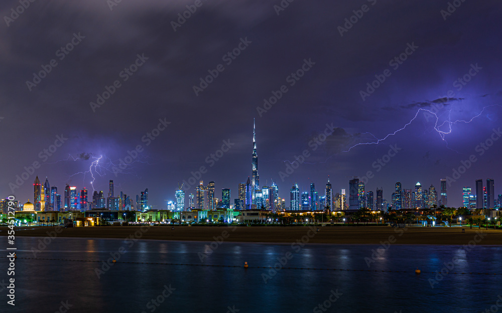 Fototapeta Night view of the Dubai city during lightning thunderstorm
