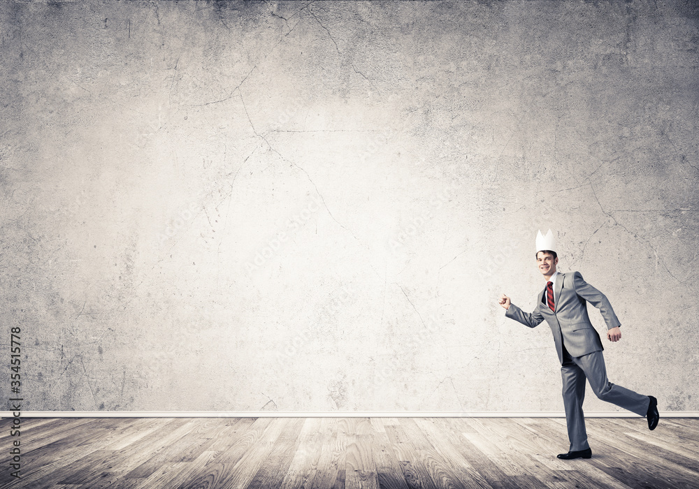 King businessman in elegant suit running in empty room King businessman in elegant suit running in empty room