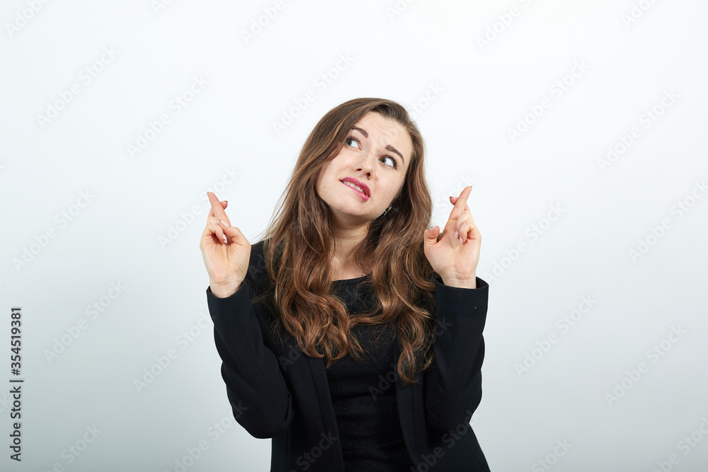 Young Attractive Woman Brunette In In A Black T-Shirt, Sweater On White Background, Exciting Female Crossed Her Fingers And Worries That Everything Will Be All Right. Hope For The Best