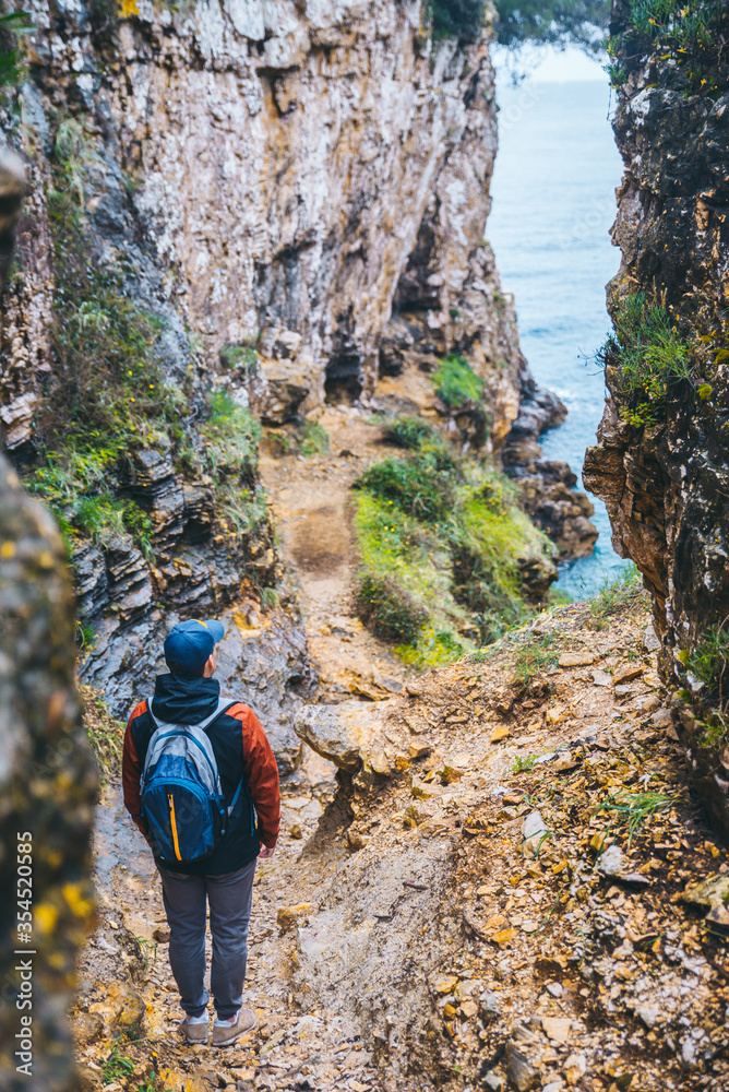 man with backpack at footpath canyon leading to sea beach man with backpack at footpath canyon leading to sea beach