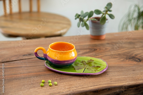 colorful handmade ceramic coffee cup on wooden table