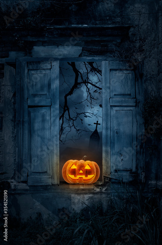 Jack O Lantern pumpkin on old damaged wood window with wall over cross, church, birds, dead tree and spooky cloudy sky, Halloween mystery concept