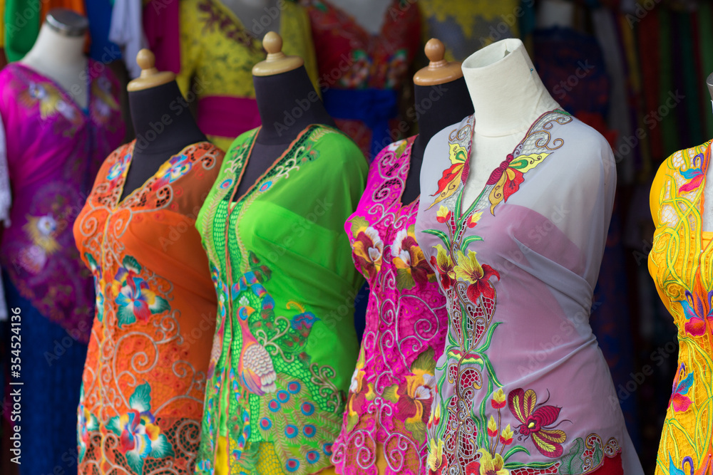 Indonesia, Bali, April 10, 2015: Colorful dresses on a market. Typical dress for local people. Orange, green, pink and yellow