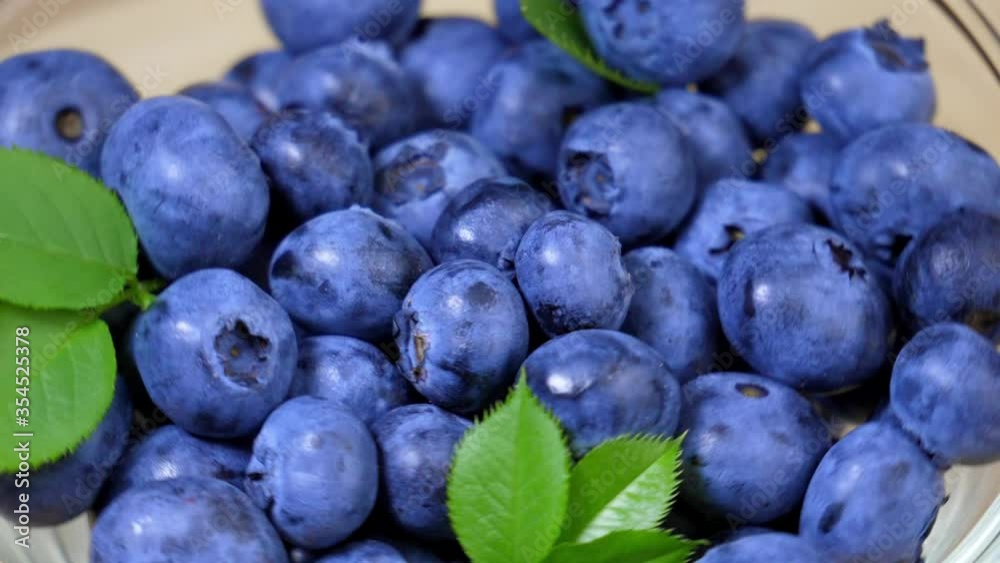 Juicy shining blueberries slowly rotating on a plate Juicy shining blueberries slowly rotating on a plate