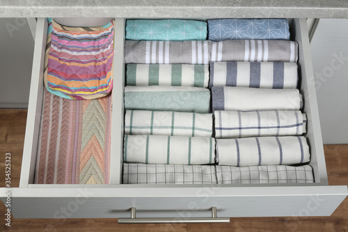 Fotografie Open drawer with folded towels. Order in kitchen