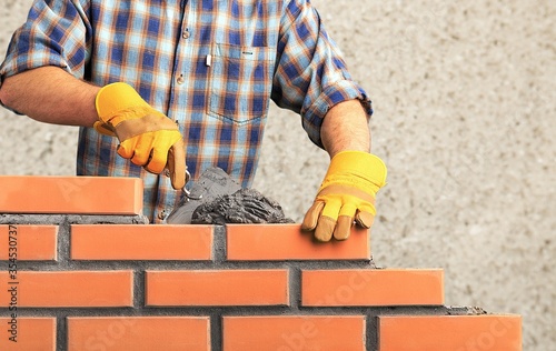Obraz na płótnie Bricklayer worker installing brick masonry