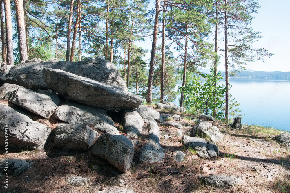 Pine forest with boulders on the shore of mountain lake Turgoyak, South Ural, Russia Pine forest with boulders on the shore of mountain lake Turgoyak, South Ural, Russia