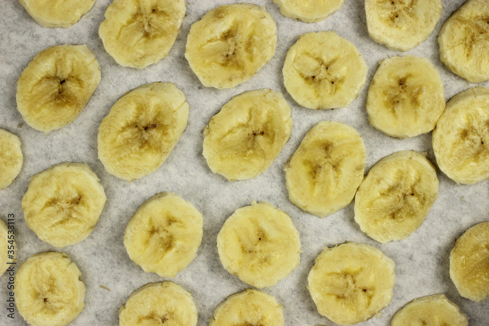 sliced banana chips on parchment paper in the oven