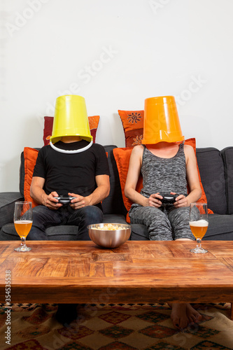 Canvas Print Young couple play video games sitting comfortably on the sofa at home