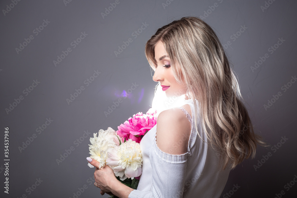 Young pretty woman with pink peonies. Spring allergy concept. space for text Young pretty woman with pink peonies. Spring allergy concept. space for text