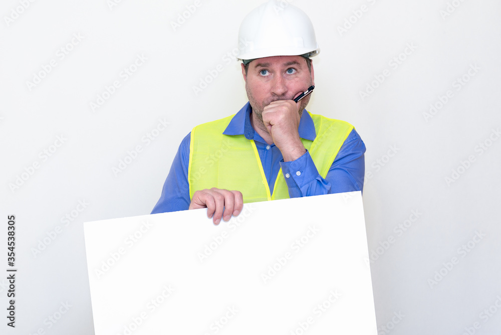 Thinking Engineer man wearing a helmet and reflector vest, standing and holding a billboard. White background. Thinking Engineer man wearing a helmet and reflector vest, standing and holding a billboard. White background.