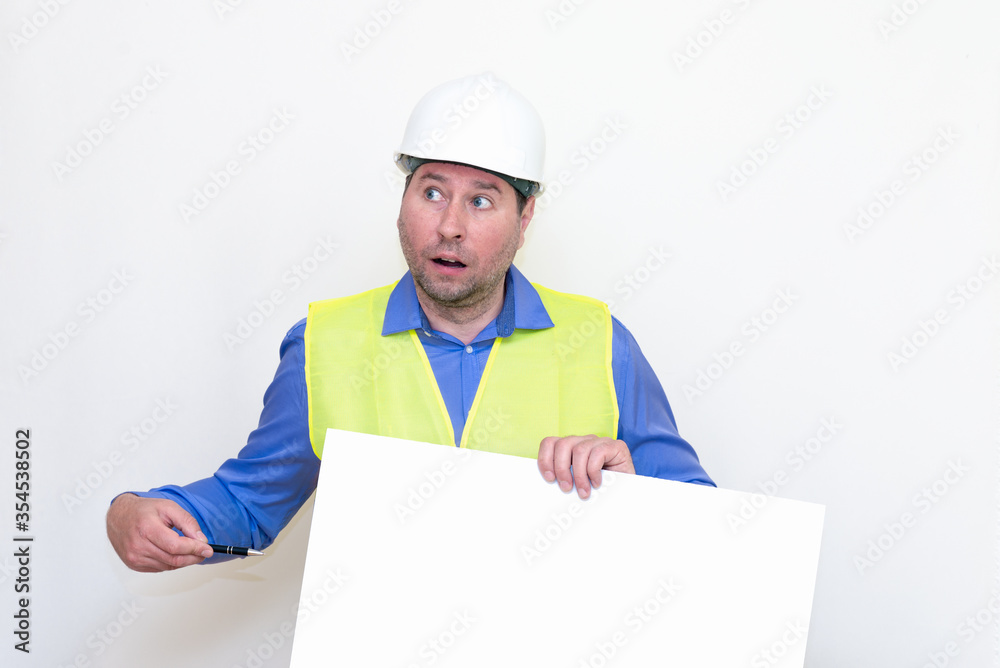Surprised Engineer man wearing a helmet and reflector vest, standing and holding a billboard. White background. Surprised Engineer man wearing a helmet and reflector vest, standing and holding a billboard. White background.
