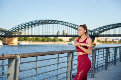 Fit in the city, young woman doing gymnastics and stretching exercises on the river early in the morning after sunrise © Marc Zimmermann