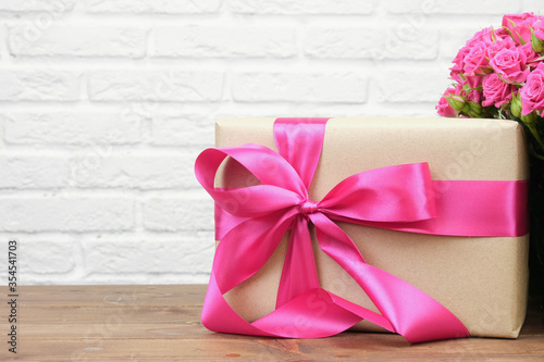 Bouquet of pink roses on a white brick wall background with copy space. The concept of flowers, floristry, holiday